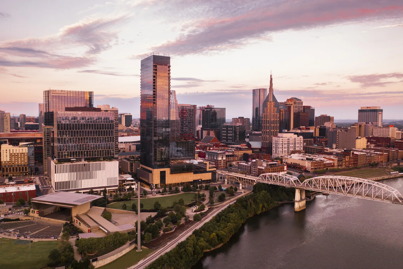 Elevated blue-hour view of SoBro with Ascend Amphitheater, the Cumberland River, and downtown hotel towers.