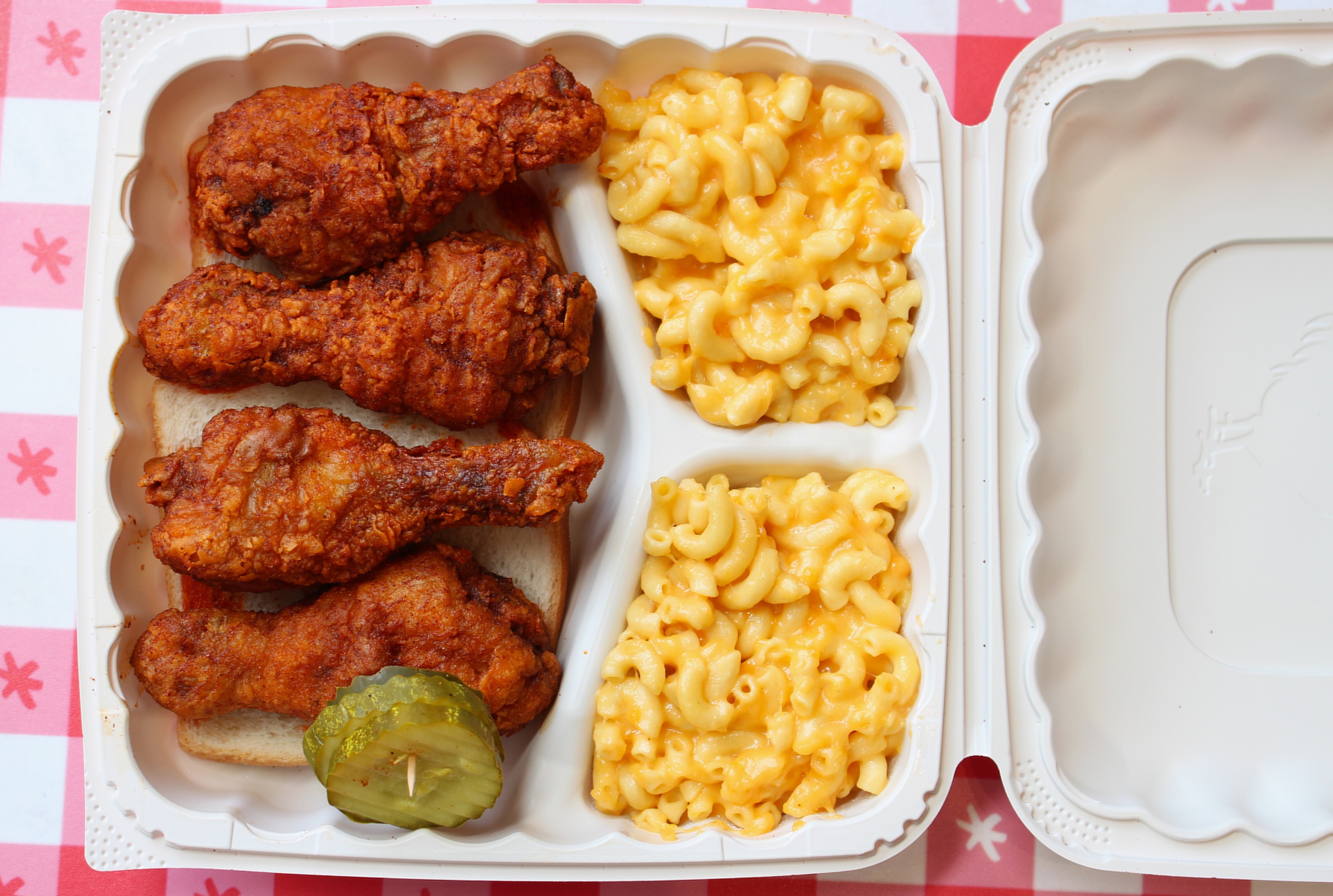 Nashville-style hot chicken drumsticks served with pickles.