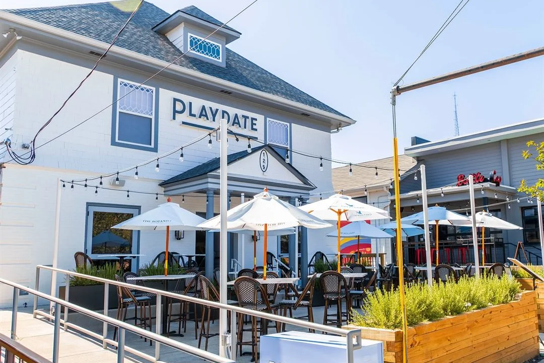 Playdate's outdoor patio with white umbrellas on 12th Avenue South.