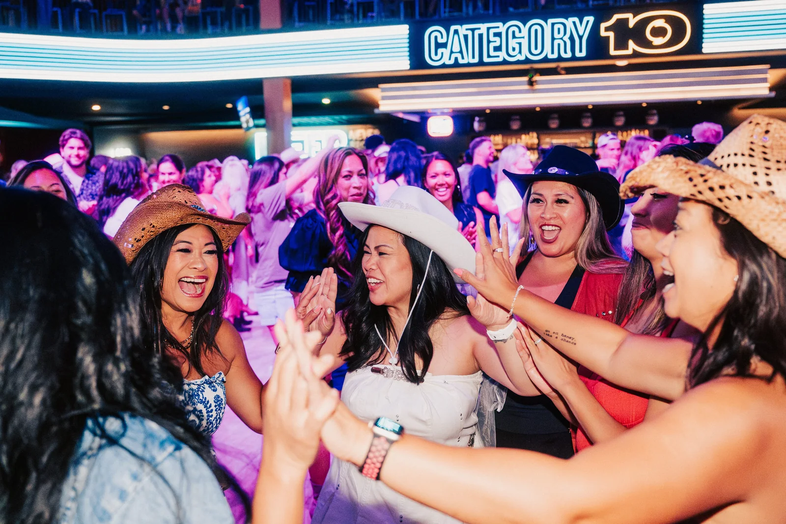 Category 10 main floor crowd with balcony mezzanine and Category 10 neon identity.