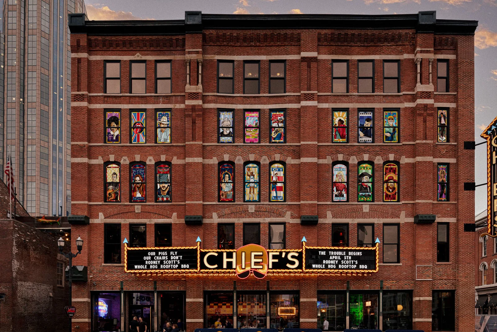 Chief's on Broadway dusk exterior with restored brick facade, stained-glass windows, and illuminated marquee.