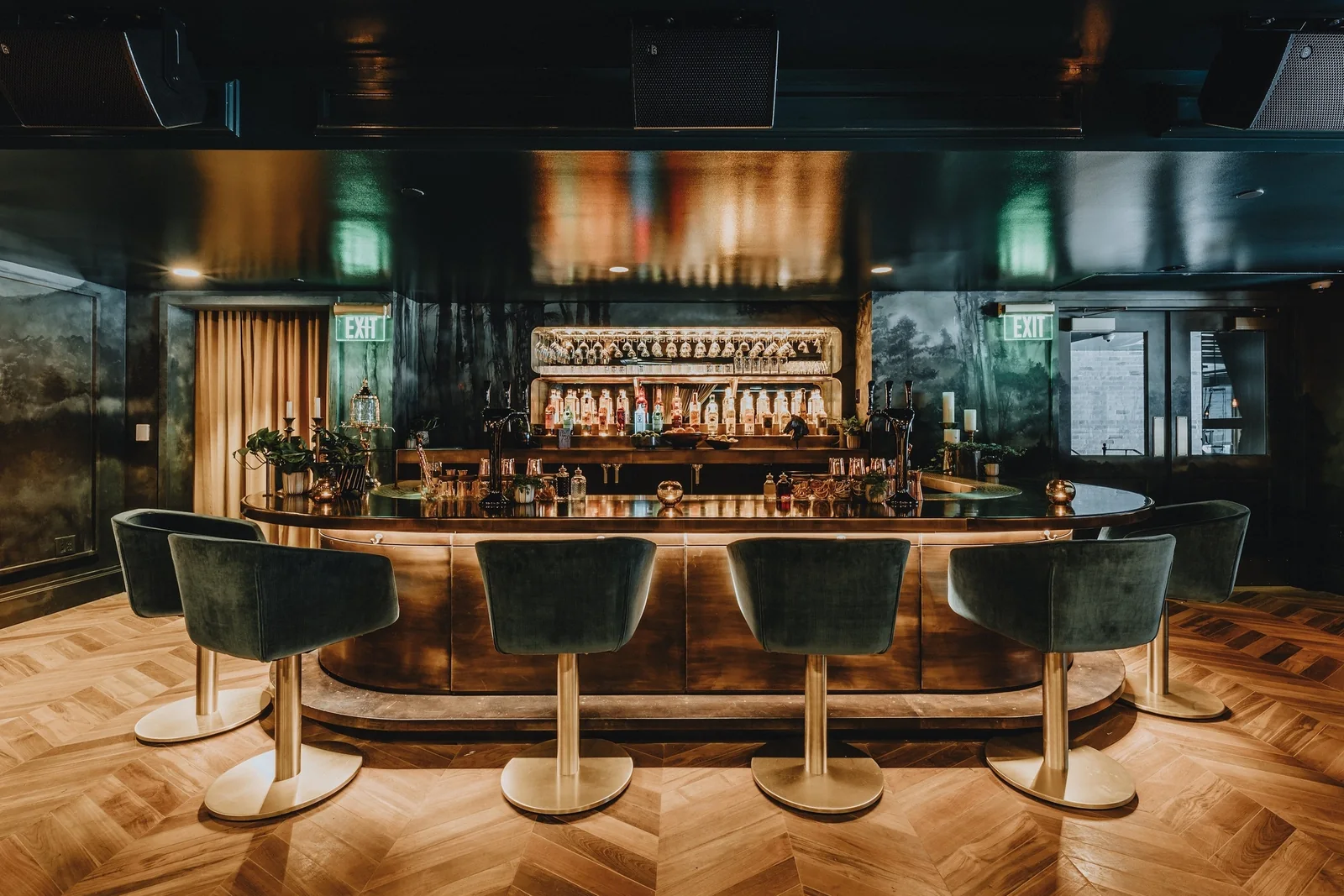 Twelve Thirty Club supper club bar with red and green leather seating, brass, marble, and dark wood.